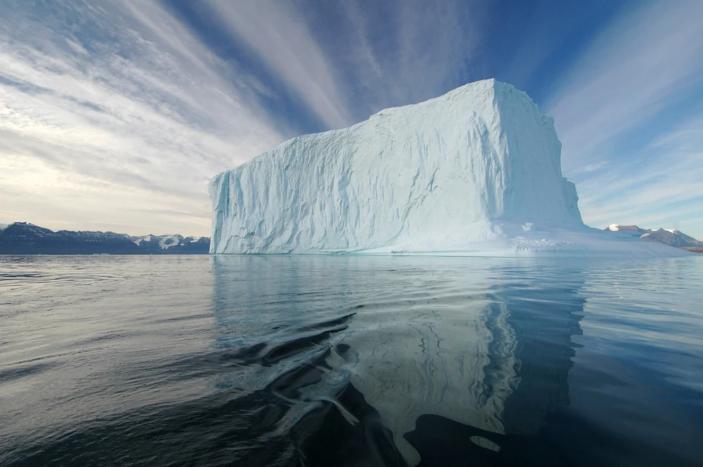 An iceberg with a small tip above the waterline and a vast mass below: the demo you see versus the production system underneath